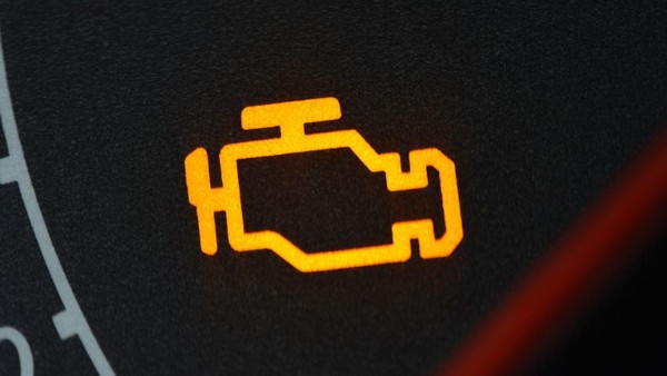 a yellow engine warning light showing on a cars dashboard